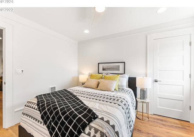 bedroom with ornamental molding and light hardwood / wood-style floors