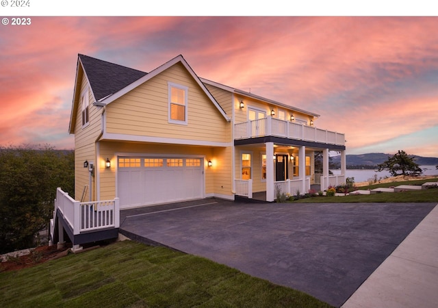 view of front of house featuring a balcony, a yard, and a garage