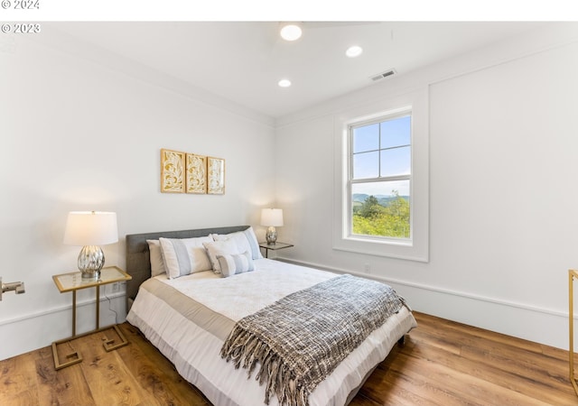 bedroom featuring crown molding and wood-type flooring