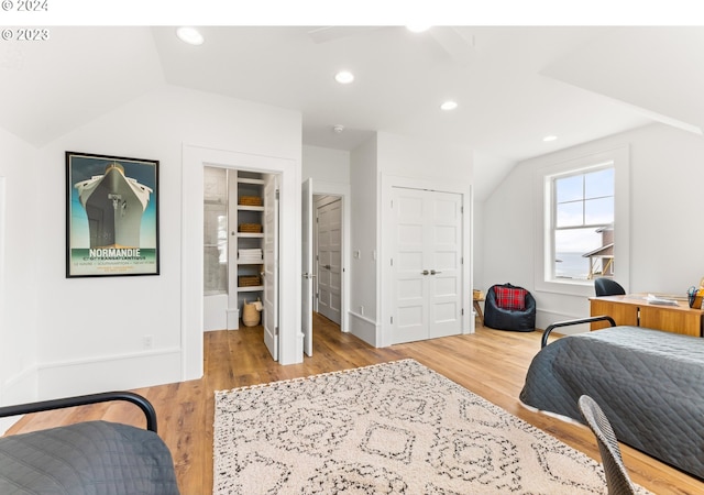 bedroom featuring ceiling fan, hardwood / wood-style floors, and lofted ceiling