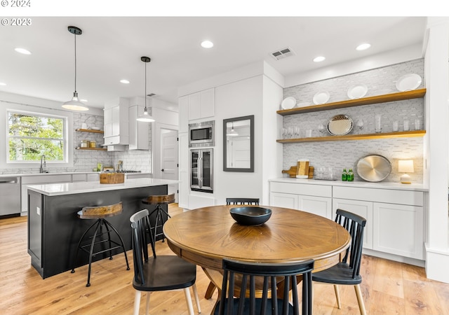 dining area with sink and light wood-type flooring