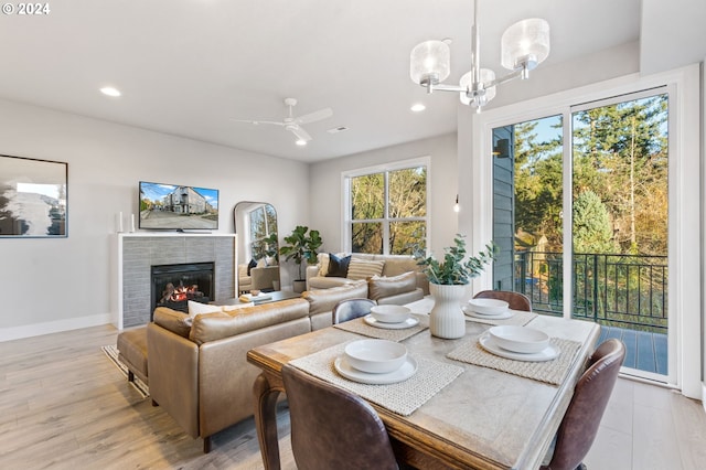 dining space with light hardwood / wood-style flooring and ceiling fan with notable chandelier