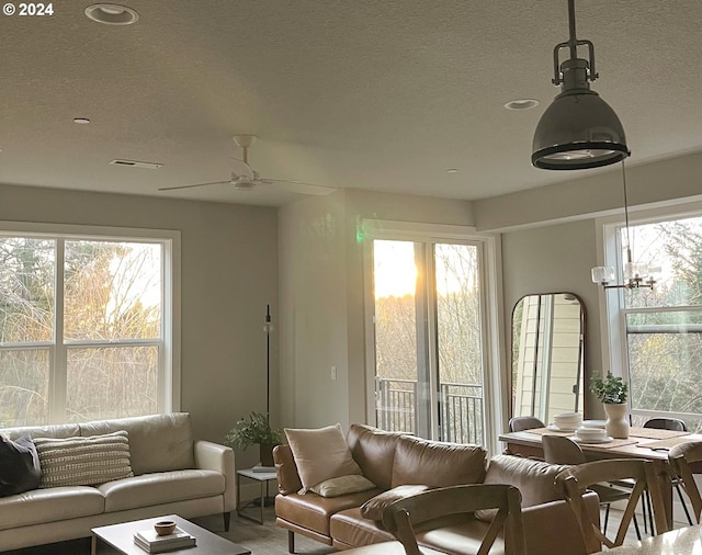 living room featuring ceiling fan with notable chandelier