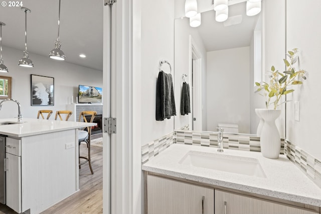 bathroom featuring wood-type flooring, vanity, and toilet