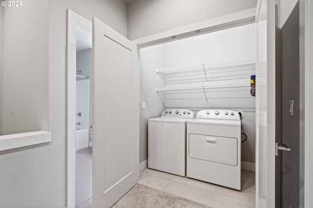 clothes washing area featuring separate washer and dryer and light tile patterned floors