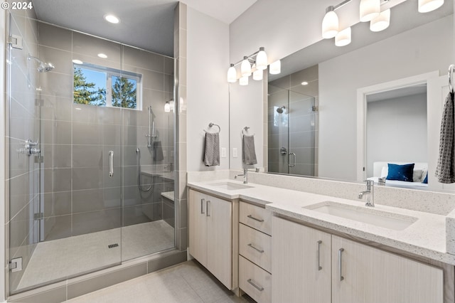 bathroom featuring a shower with door, vanity, and tile patterned flooring