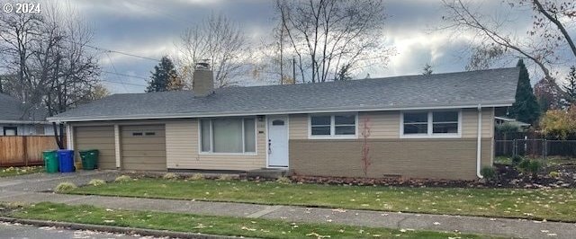 single story home with a garage and a front lawn