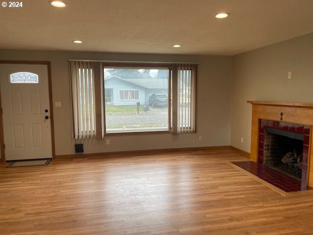 unfurnished living room with a fireplace and light hardwood / wood-style flooring