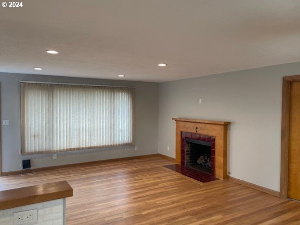 unfurnished living room with light hardwood / wood-style floors and a tile fireplace