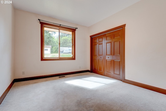 unfurnished bedroom featuring carpet and a closet