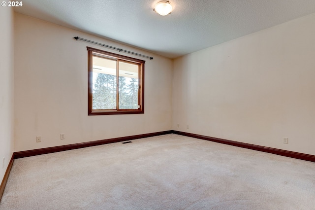 carpeted spare room with a textured ceiling