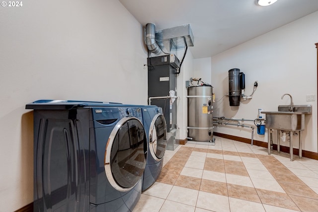 clothes washing area featuring separate washer and dryer, water heater, and light tile patterned flooring