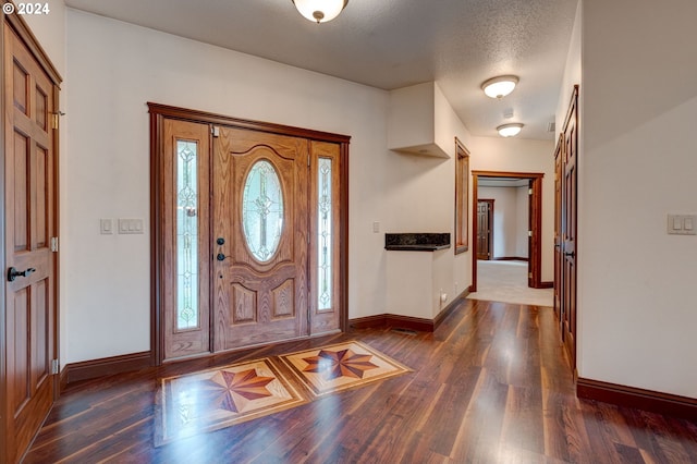 entryway with dark hardwood / wood-style flooring and a textured ceiling