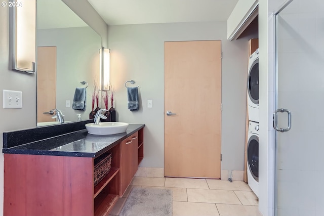 bathroom featuring tile patterned flooring, stacked washer / drying machine, an enclosed shower, and vanity