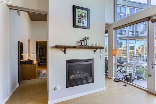 living room with a high ceiling, light hardwood / wood-style floors, and a wealth of natural light