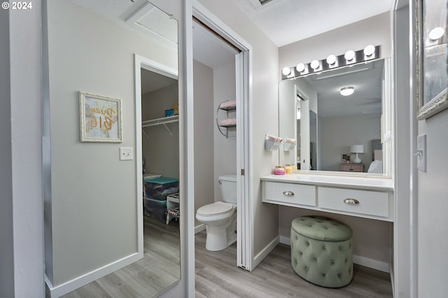 bathroom with toilet, vanity, and hardwood / wood-style flooring