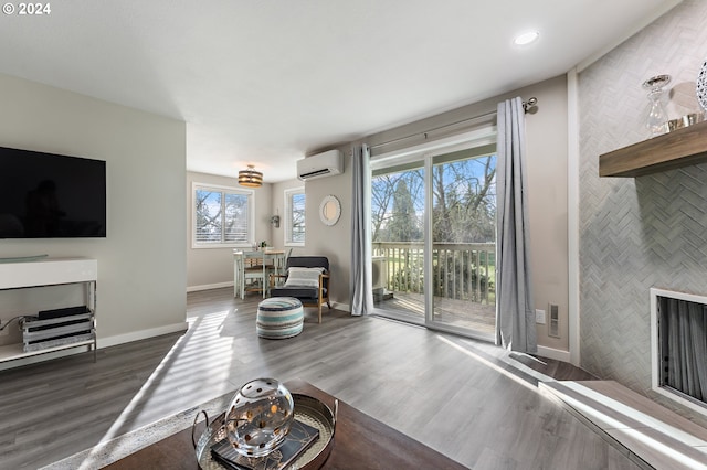 living room with a healthy amount of sunlight, dark hardwood / wood-style flooring, an AC wall unit, and tile walls