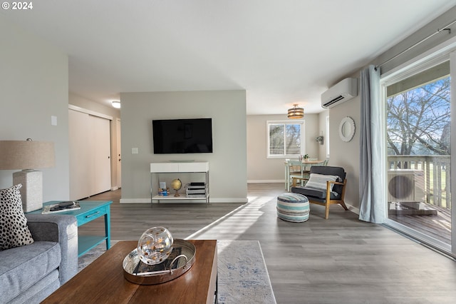 living room with wood-type flooring and an AC wall unit