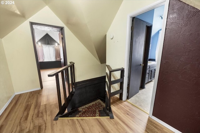 stairs featuring hardwood / wood-style floors and lofted ceiling