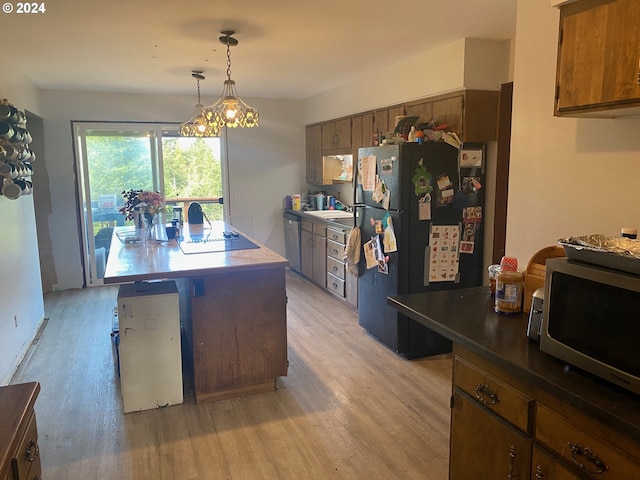 kitchen featuring sink, decorative light fixtures, light hardwood / wood-style flooring, and stainless steel appliances