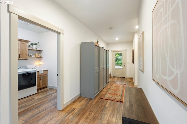 corridor featuring dark hardwood / wood-style flooring, washer / clothes dryer, and sink