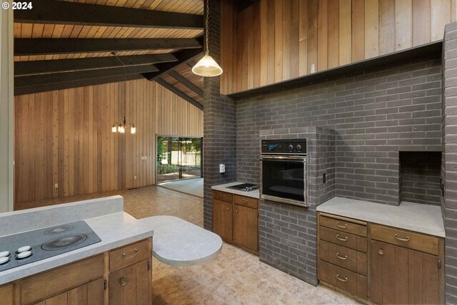 kitchen featuring wood ceiling, brick wall, hanging light fixtures, and oven