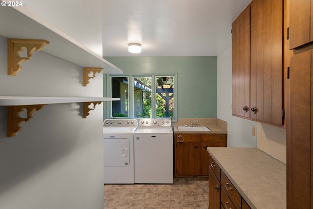 laundry area with light tile patterned flooring, sink, separate washer and dryer, and cabinets