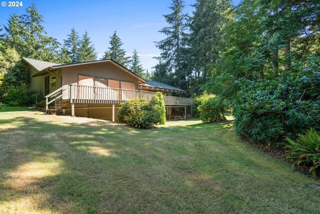 view of side of property with a lawn and a deck