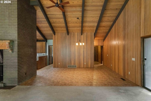 unfurnished living room featuring ceiling fan with notable chandelier, carpet, beam ceiling, wood walls, and wood ceiling