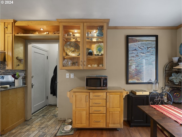 kitchen with ornamental molding, dark wood-type flooring, and backsplash