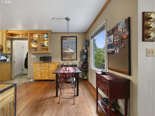 dining area featuring ornamental molding and light hardwood / wood-style floors