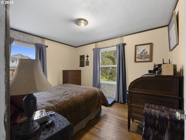 bedroom featuring crown molding and wood-type flooring