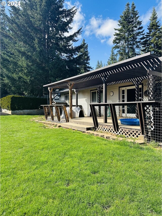 rear view of property with a pergola, a lawn, and a patio