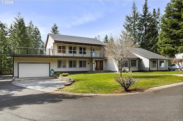 view of front of property featuring a front yard, a balcony, and a garage