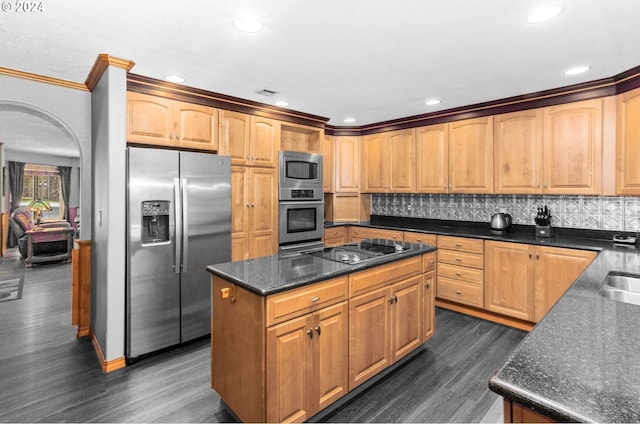 kitchen featuring dark hardwood / wood-style floors, backsplash, crown molding, a kitchen island, and appliances with stainless steel finishes