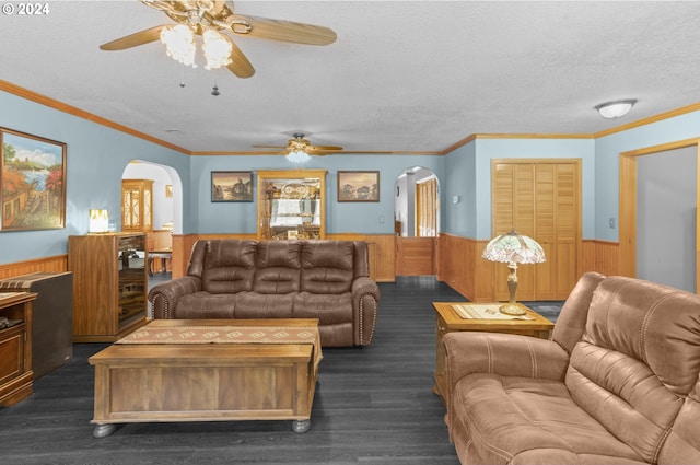 living room with wood walls, crown molding, ceiling fan, and a textured ceiling