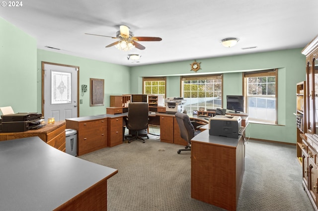 carpeted home office featuring ceiling fan