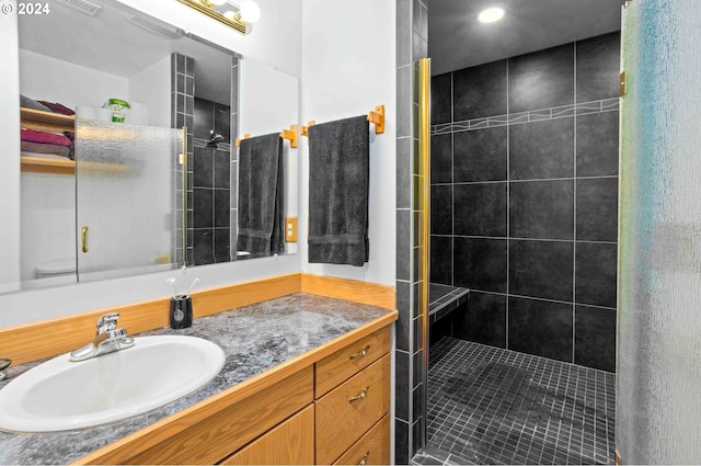 bathroom featuring a tile shower and vanity