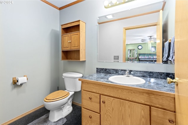 bathroom with ceiling fan, vanity, ornamental molding, and toilet