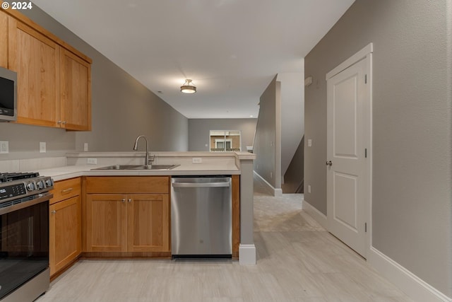 kitchen with kitchen peninsula, appliances with stainless steel finishes, and sink