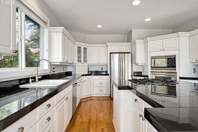 kitchen with light hardwood / wood-style flooring, sink, stainless steel appliances, and white cabinetry