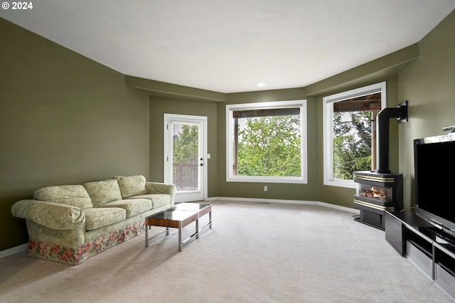 living room with a wood stove and light colored carpet