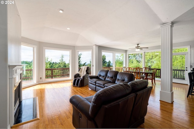 living room with decorative columns, light hardwood / wood-style flooring, and ceiling fan