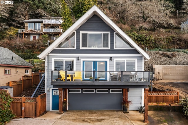 rear view of property featuring a balcony and a garage