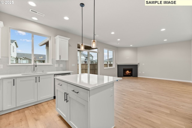 1376 NE Josephine Ct Unit 184, Estacada, OR 97023 - kitchen with a sink, light wood-type flooring, visible vents, backsplash, and light countertops