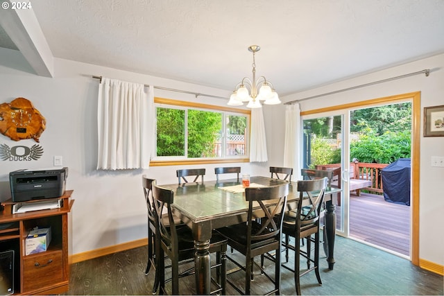 dining space with dark hardwood / wood-style flooring, a notable chandelier, a textured ceiling, and a wealth of natural light