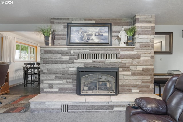 living room with a stone fireplace and a textured ceiling