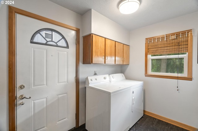 laundry room with a textured ceiling, cabinets, washing machine and clothes dryer, and dark hardwood / wood-style flooring