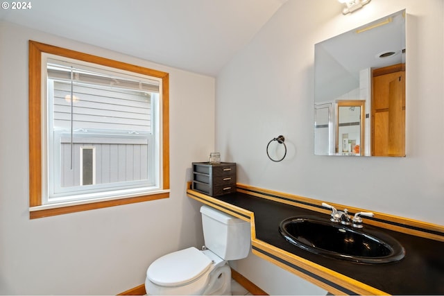 bathroom with lofted ceiling, sink, and toilet