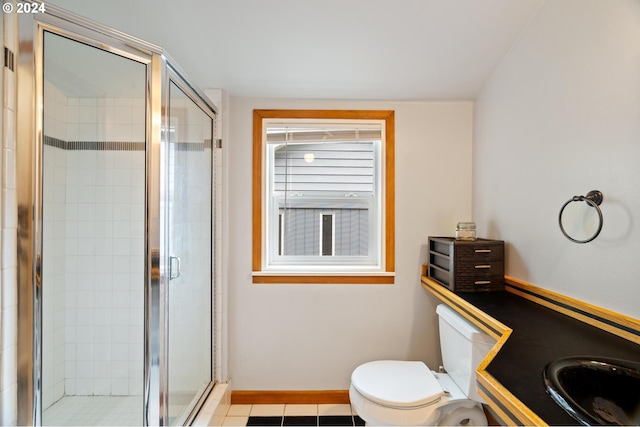 bathroom featuring vanity, toilet, tile patterned floors, and a shower with shower door